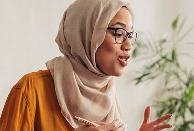 Muslim businesswoman working at home due to pandemic isolation  Female wearing hijab talking over a video call with team 