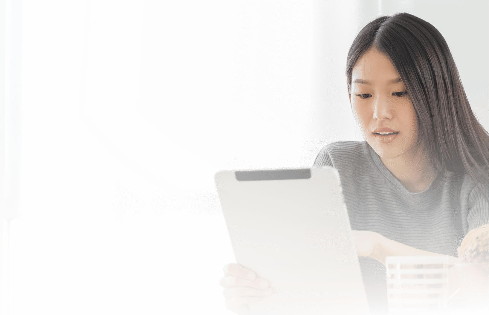 Young Asian woman using tablet at home and having breakfast in the morning  She reading on tablet 